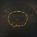 Gold-tone link bracelet with green flower charms and centered floral motif