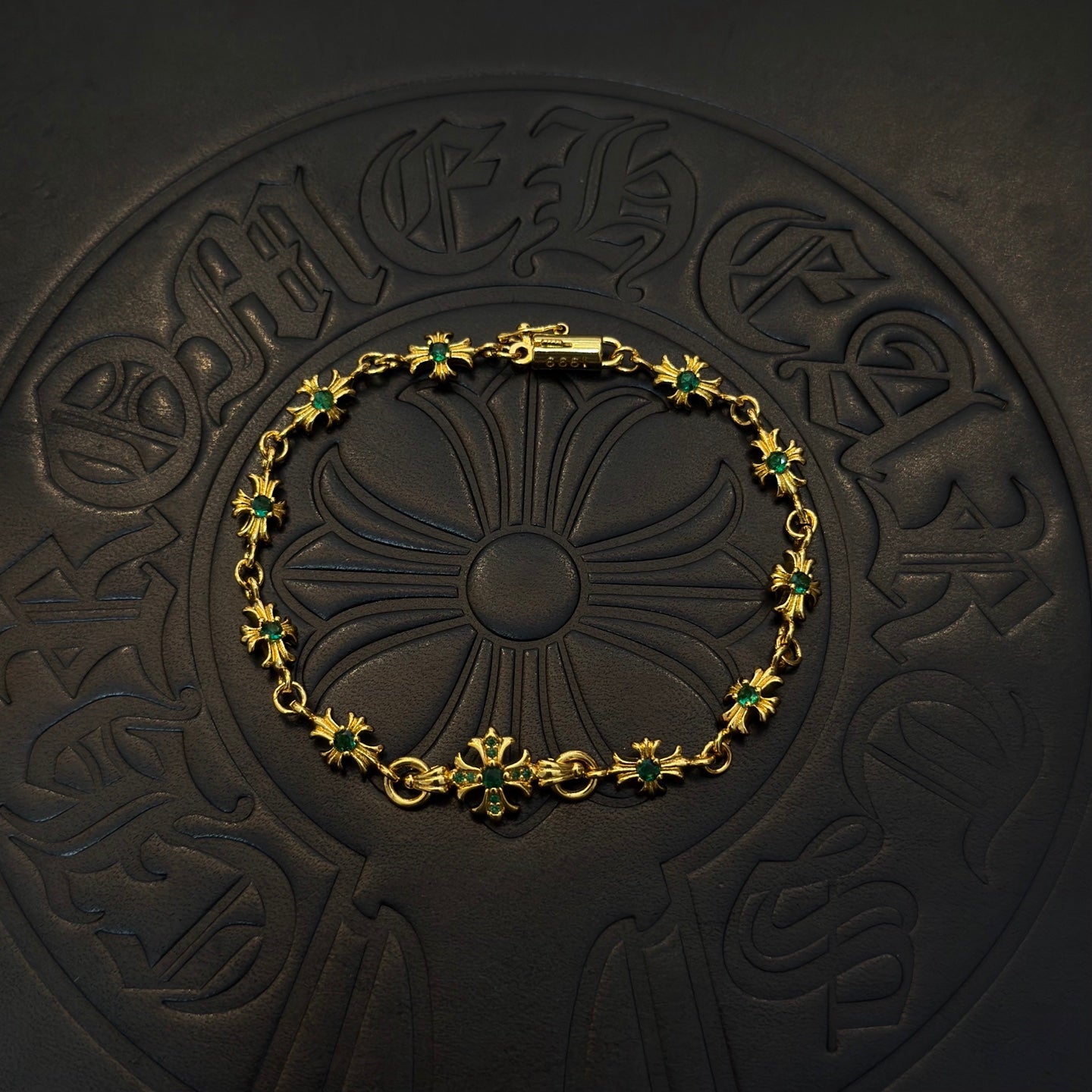 Gold-tone link bracelet with green flower charms and centered floral motif