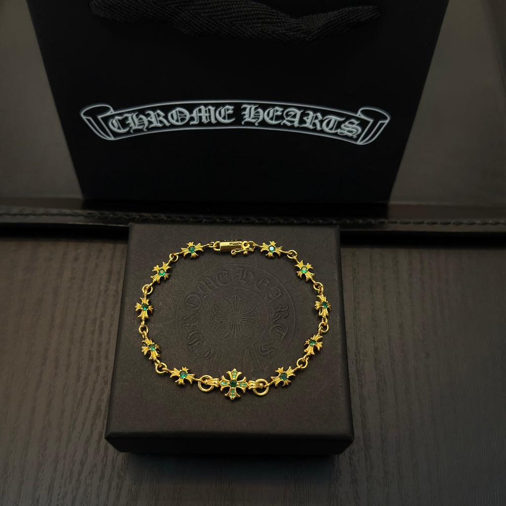 Gold-tone link bracelet with green flower charms in a black display box