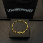 Gold-tone link bracelet with green flower charms in a black display box