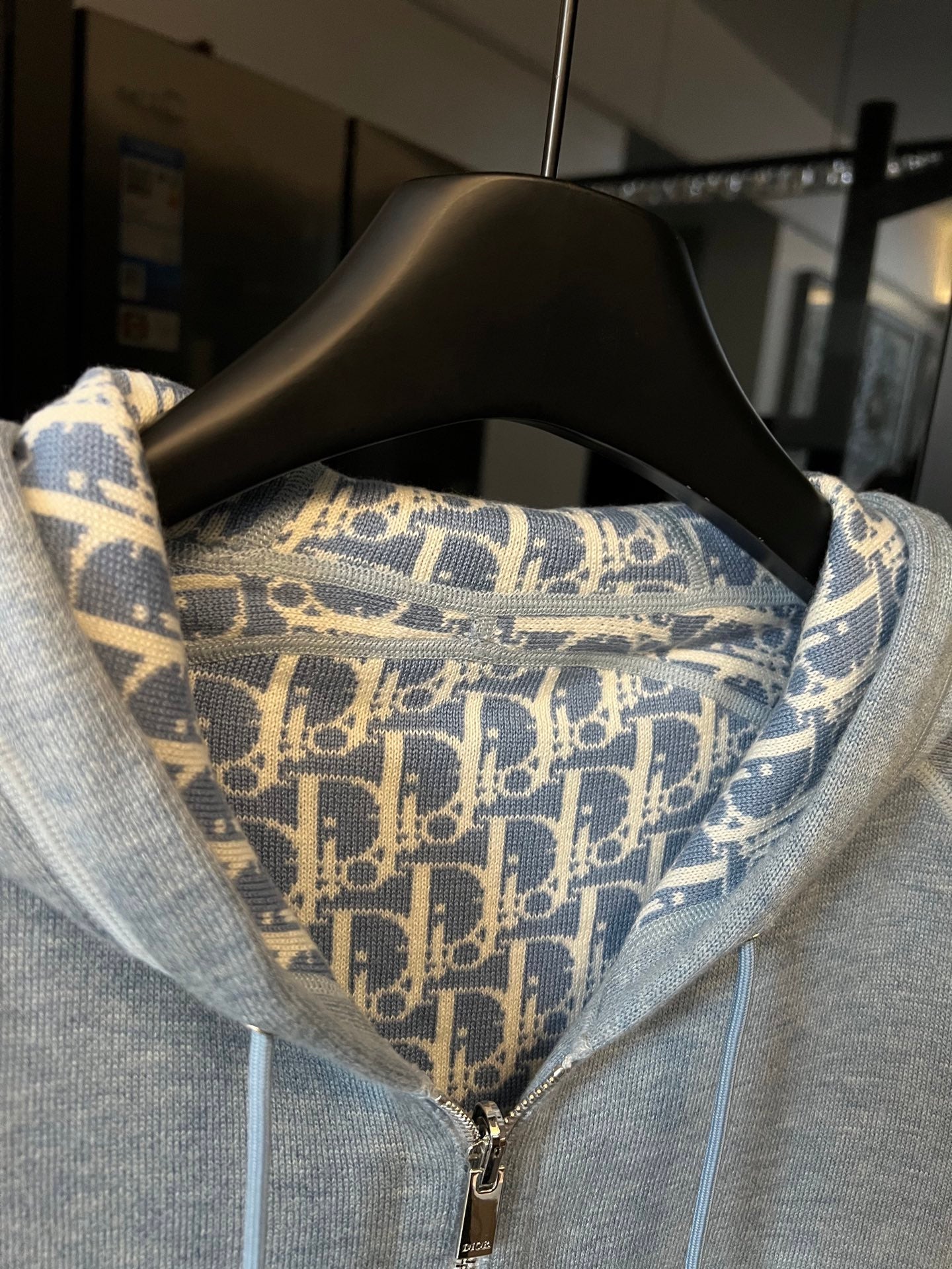Light gray zip-up hoodie with patterned hood lining and metal front zipper
