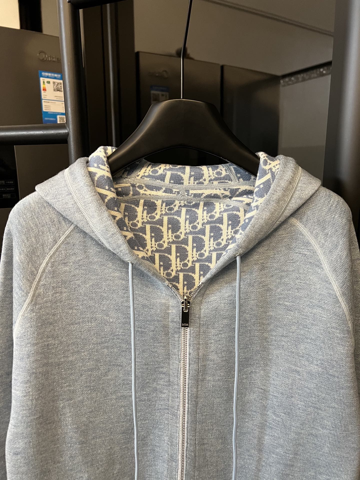 Light gray zip-up hoodie with hood and full front zipper, patterned inner lining