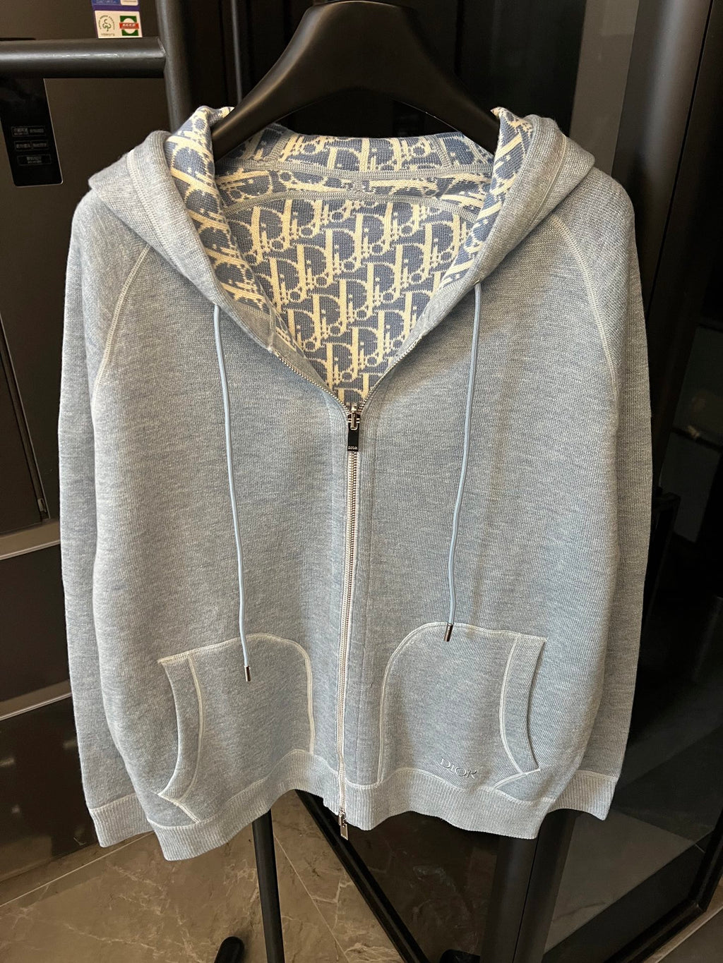 Light gray zip-up hoodie with hood, front zipper, and patterned hood lining