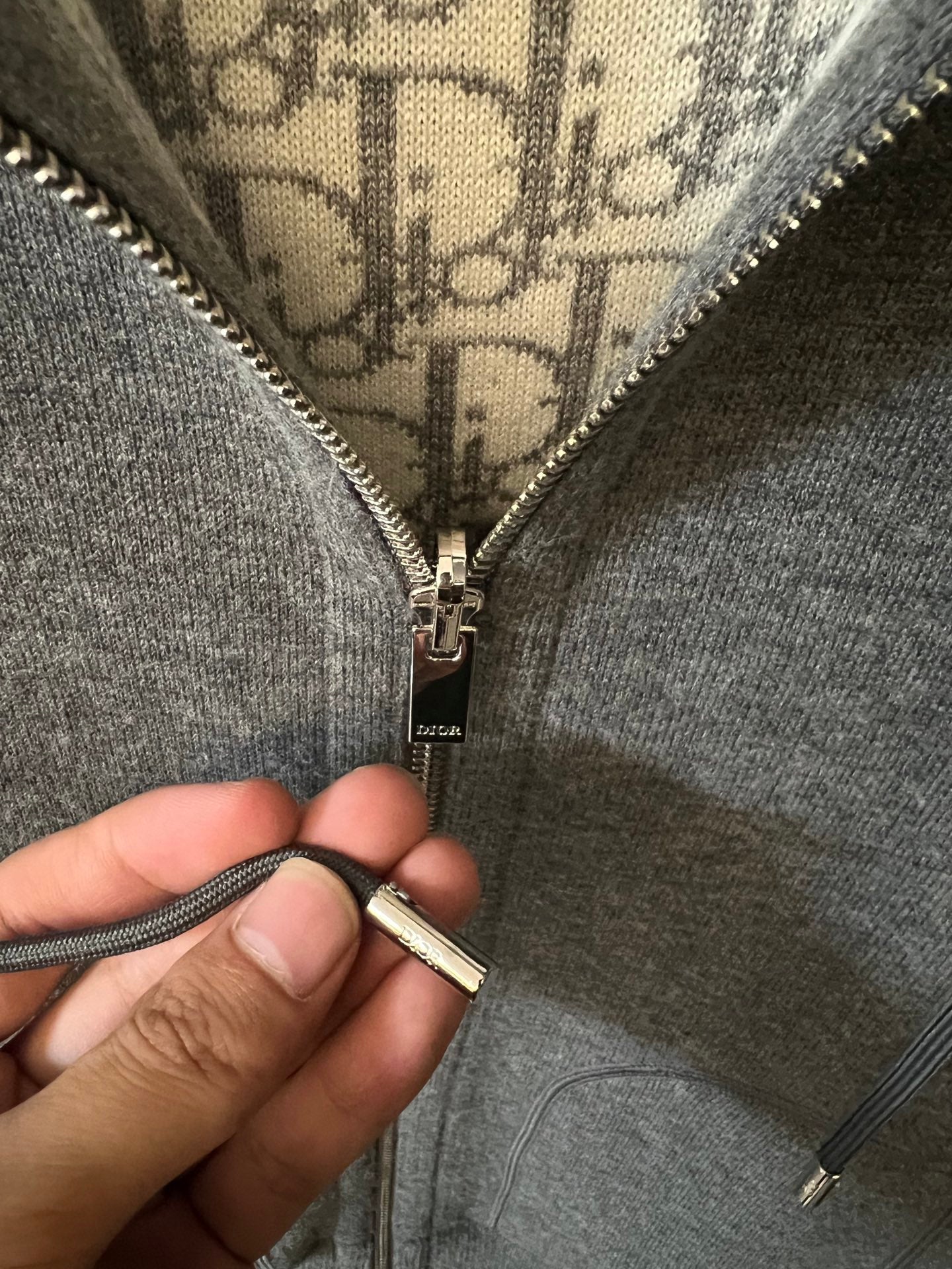 Gray heather zip-up hoodie with metal zipper pull and front zipper details