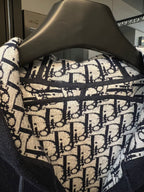 Dior monogram hood lining fabric with navy trim on a dark hoodie.