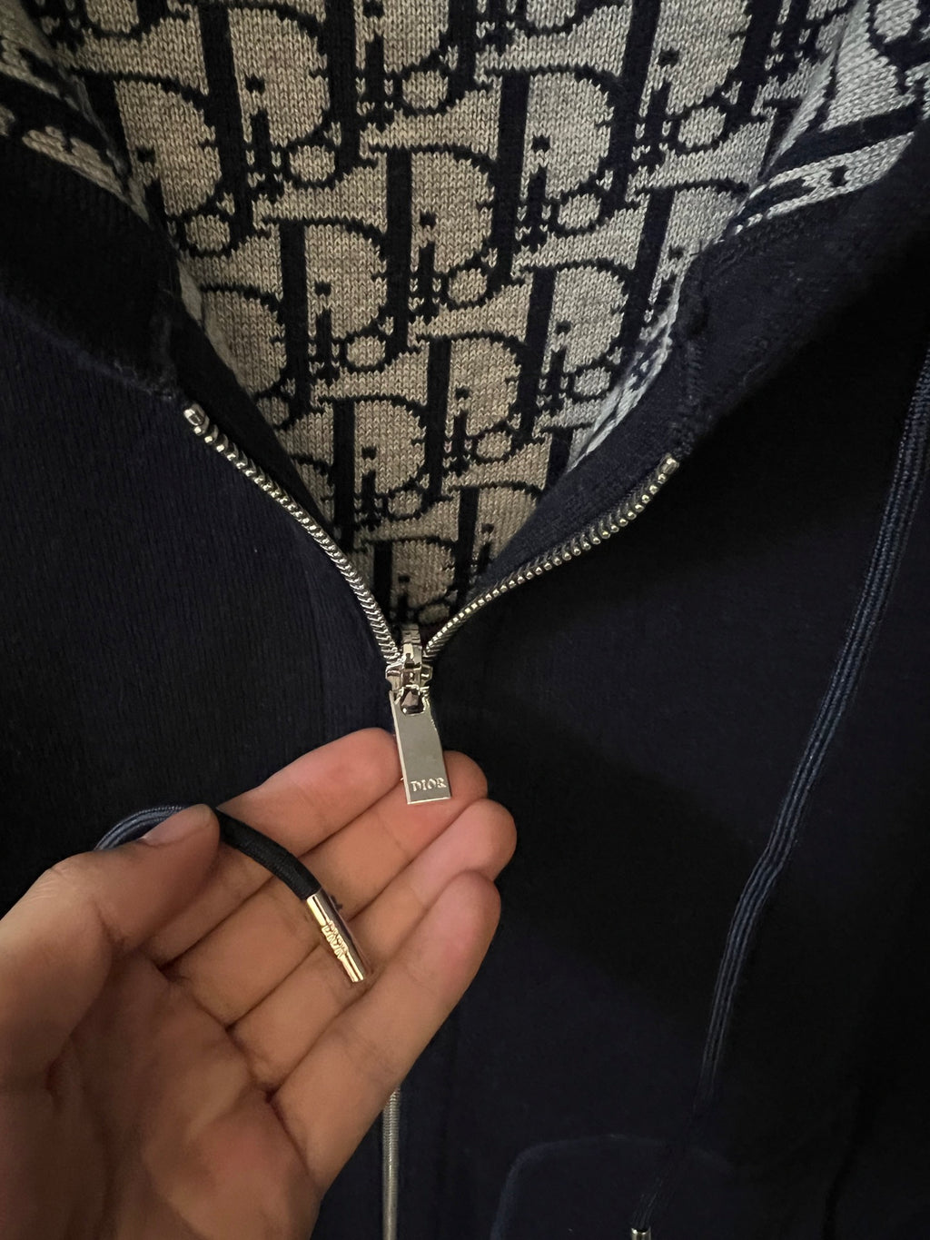 Dark zip hoodie zipper pull with Dior monogram inner hood lining.