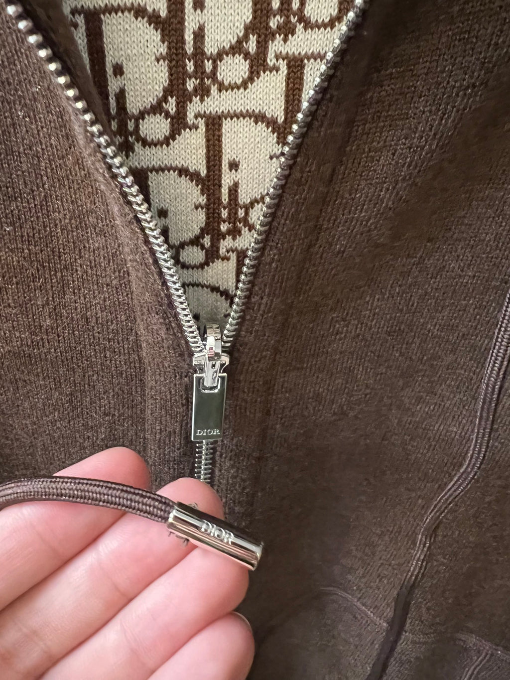 Dior zip-up hoodie zipper pull with patterned lining close-up