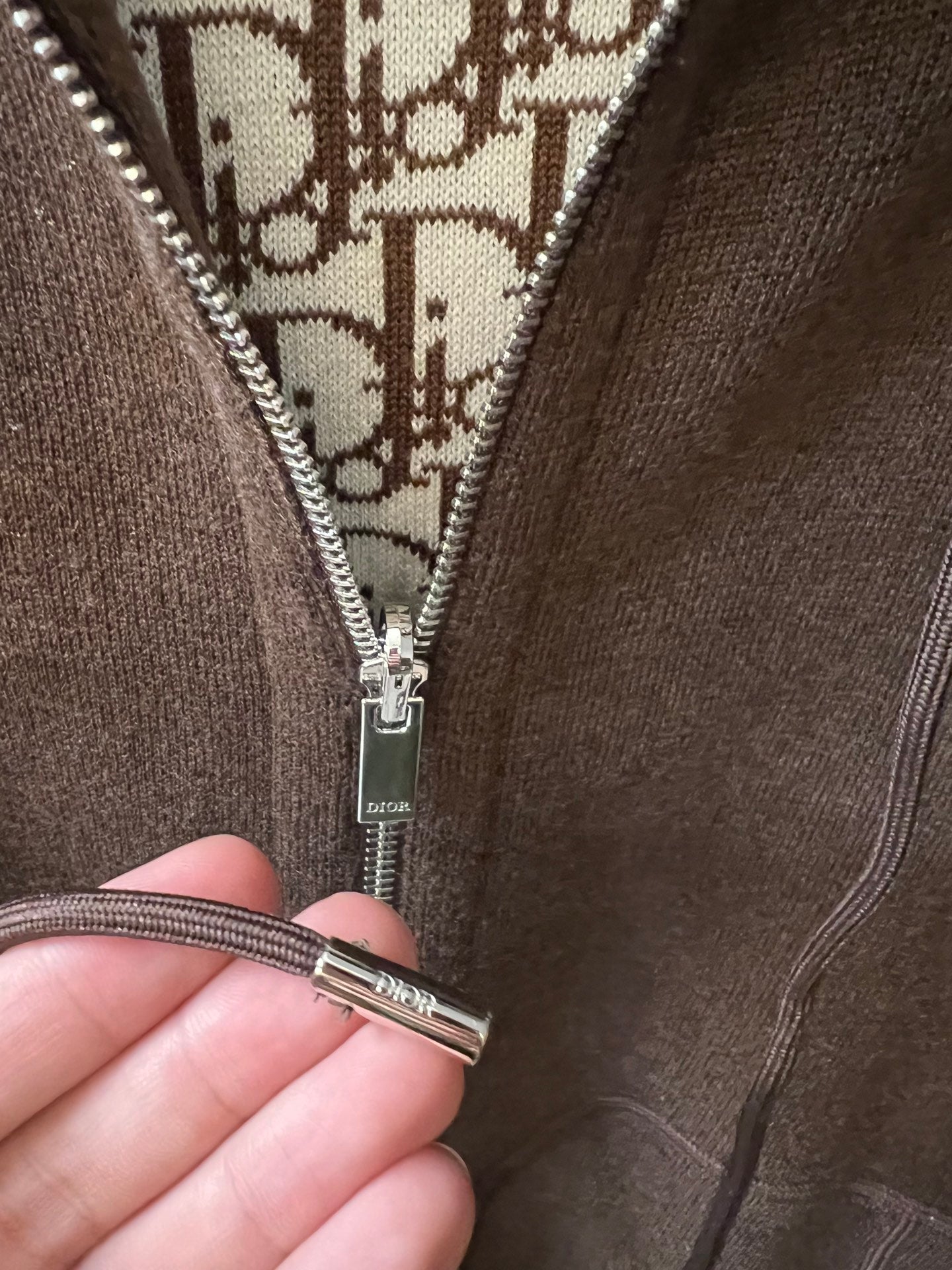 Dior zip-up hoodie zipper pull with patterned lining close-up