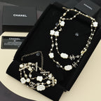 Pearl charm necklace with white shell flower charms on a black jewelry display tray