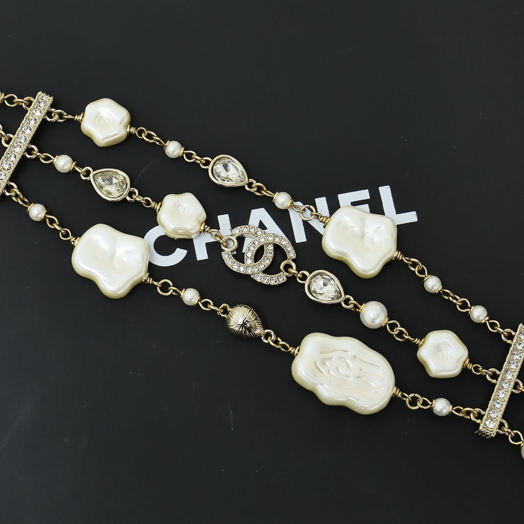 Charm bracelet with gold-tone chain, white shell heart beads, pearls, and crystal accents