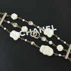Charm bracelet with gold-tone chain, white shell heart beads, pearls, and crystal accents