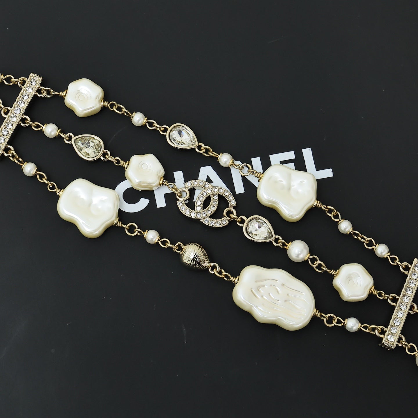 Charm bracelet with gold-tone chain, white shell heart beads, pearls, and crystal accents