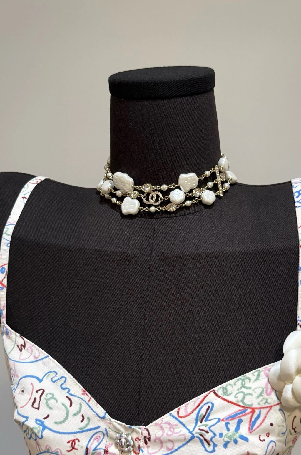 Pearl charm necklace with white shell clover charms and gold-tone chain on a mannequin