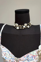 Pearl charm necklace with white shell clover charms and gold-tone chain on a mannequin