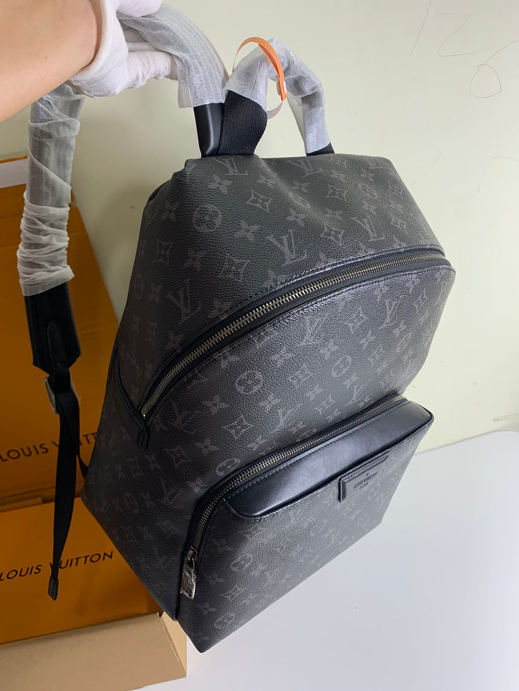 Louis Vuitton monogram backpack with front zip and shoulder straps, dark gray