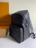 Louis Vuitton monogram backpack with front pocket and top zip, black leather trim