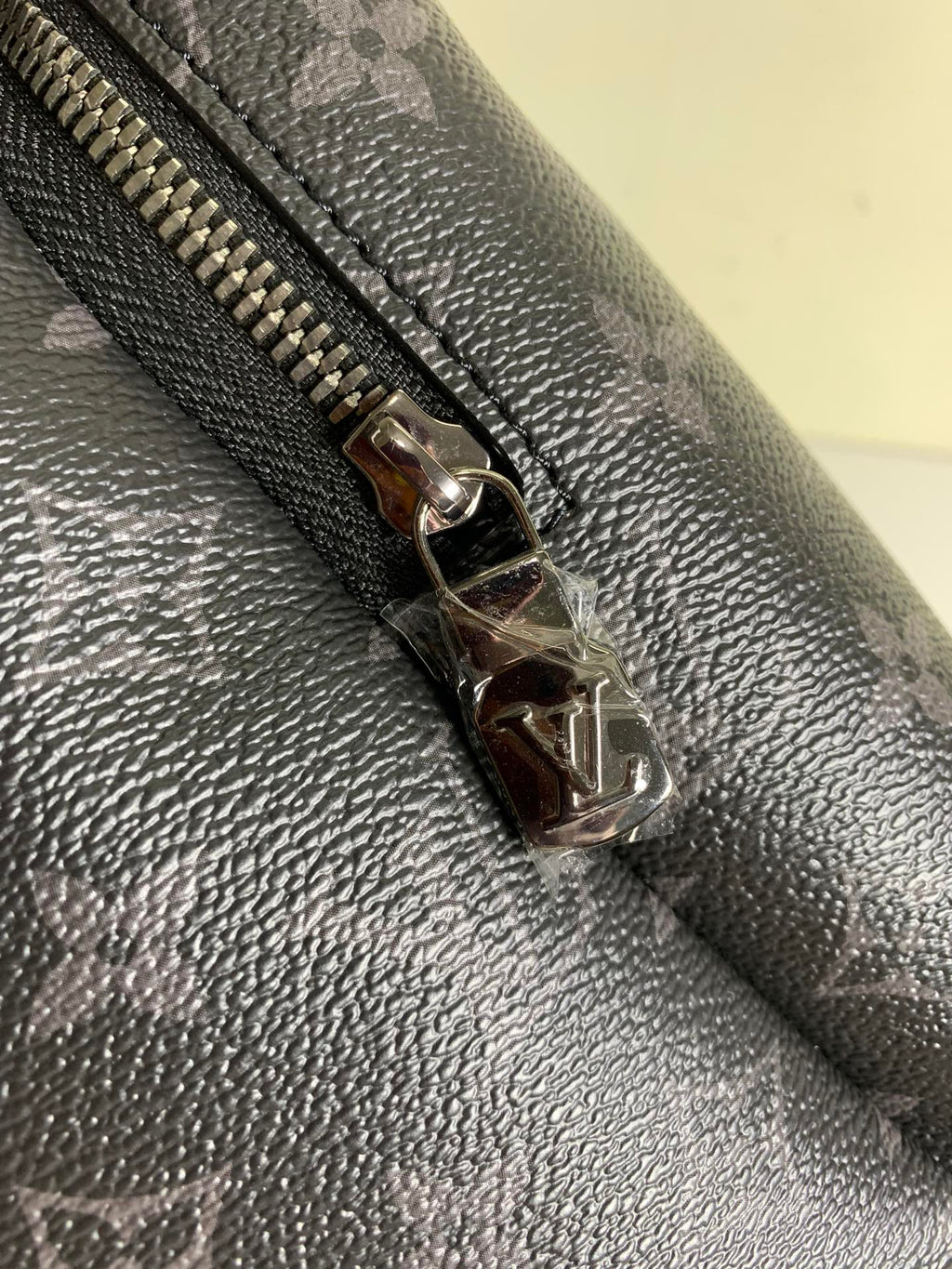 Louis Vuitton monogram backpack zipper pull, silver-tone hardware on leather