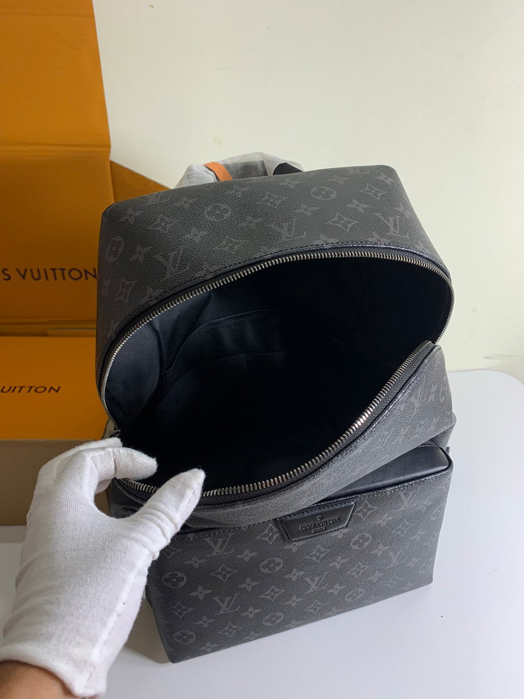 Louis Vuitton monogram backpack front pocket open, showing dark interior