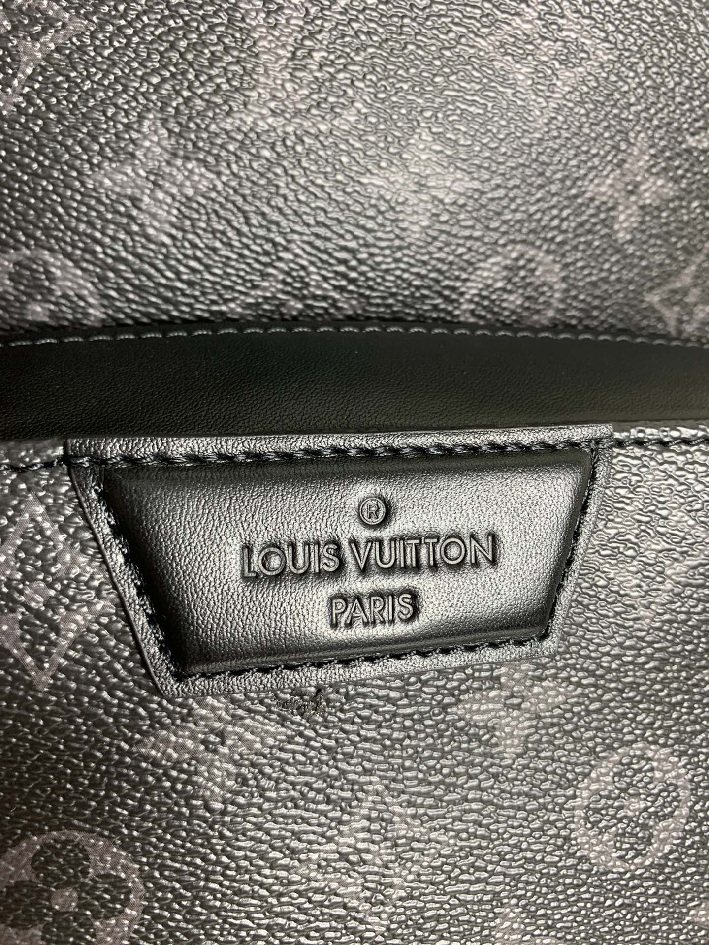 Louis Vuitton Paris leather label on dark monogram bag, textured surface