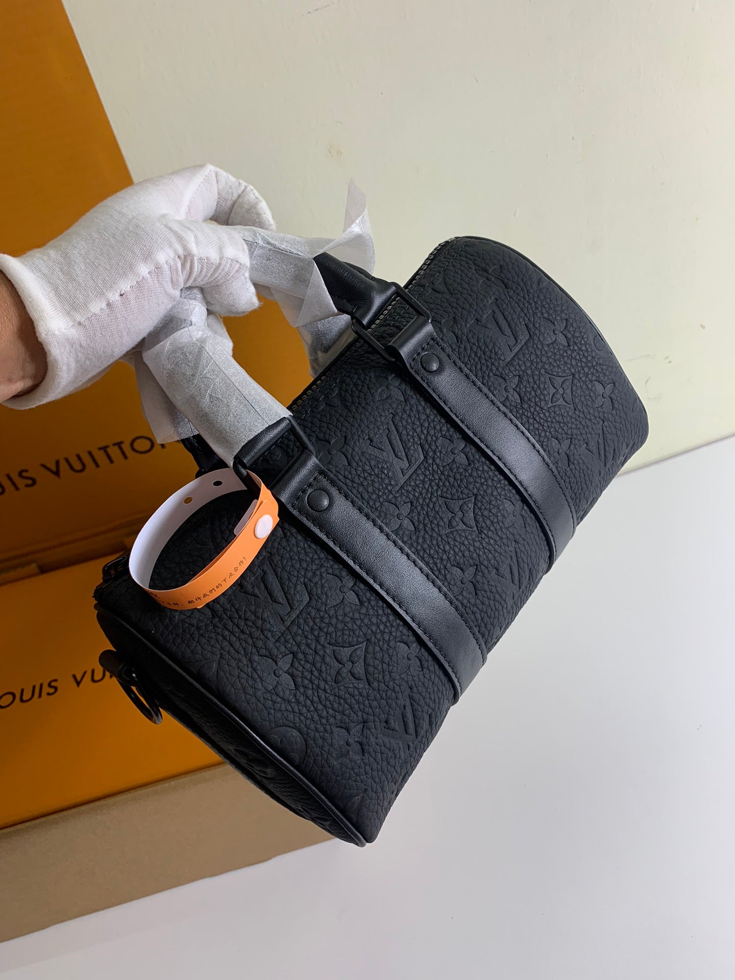 Louis Vuitton dark monogram bag with front buckles and orange key strap