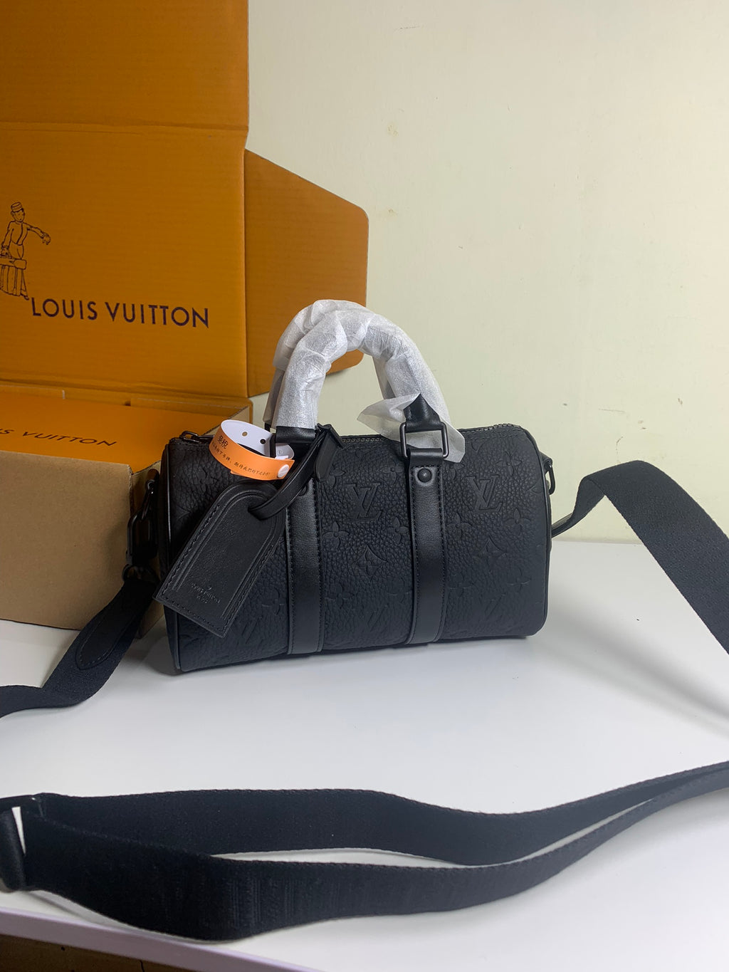 Louis Vuitton bag in dark textured leather with short handles and crossbody strap