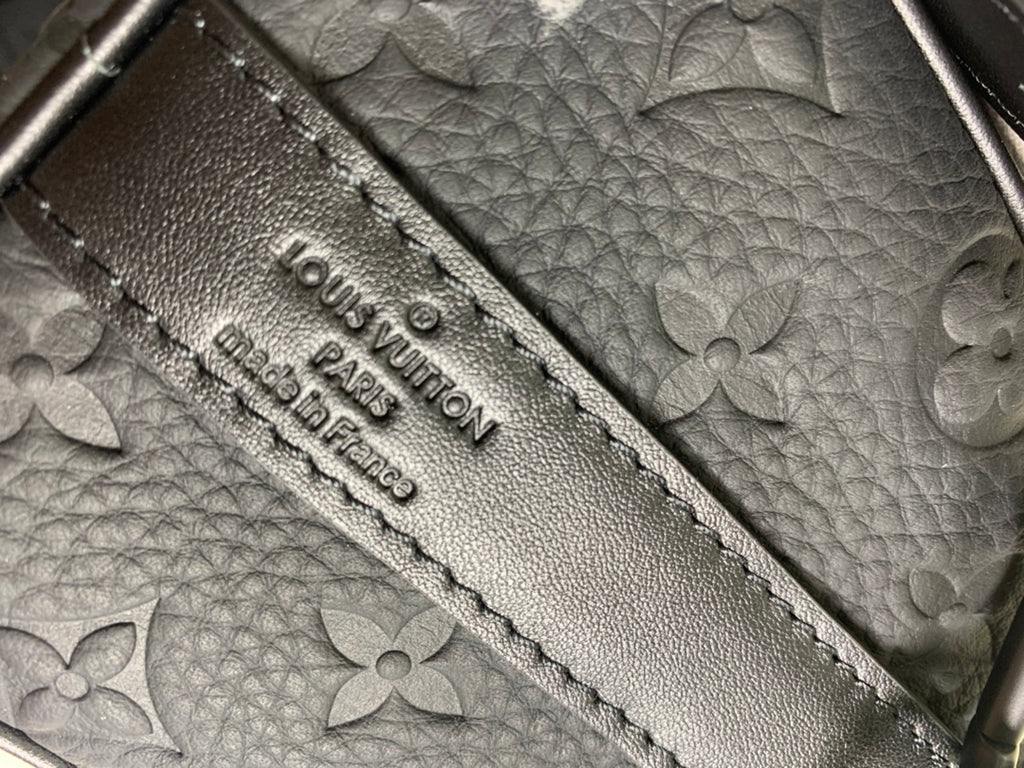 Louis Vuitton bag interior panel with embossed logo text and decorative stitching
