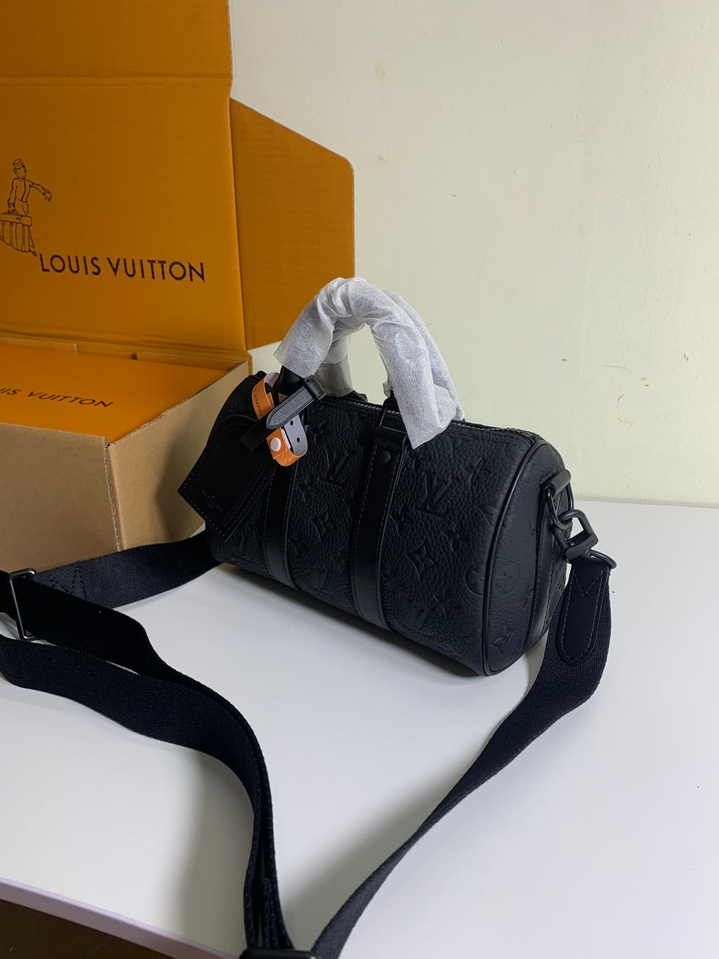 Louis Vuitton bag with top handle, dark leather body, and long shoulder strap
