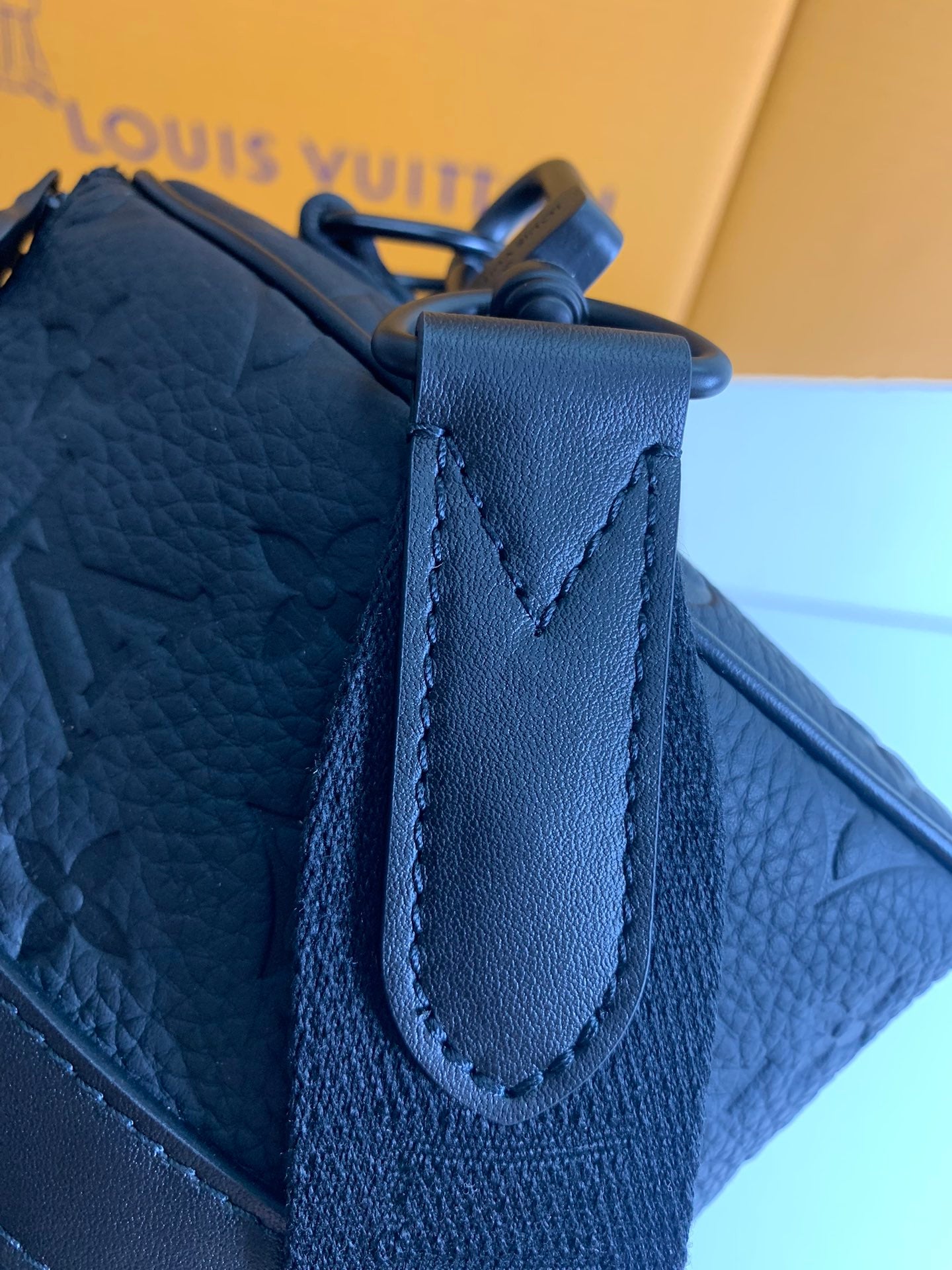 Louis Vuitton blue leather bag with top flap, stitched handle loop, and strap