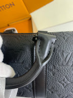 Louis Vuitton bag side view with embossed monogram texture and black strap hardware