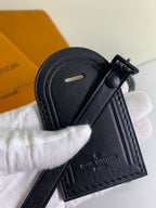 Louis Vuitton dark leather key holder with snap and monogram-embossed tag