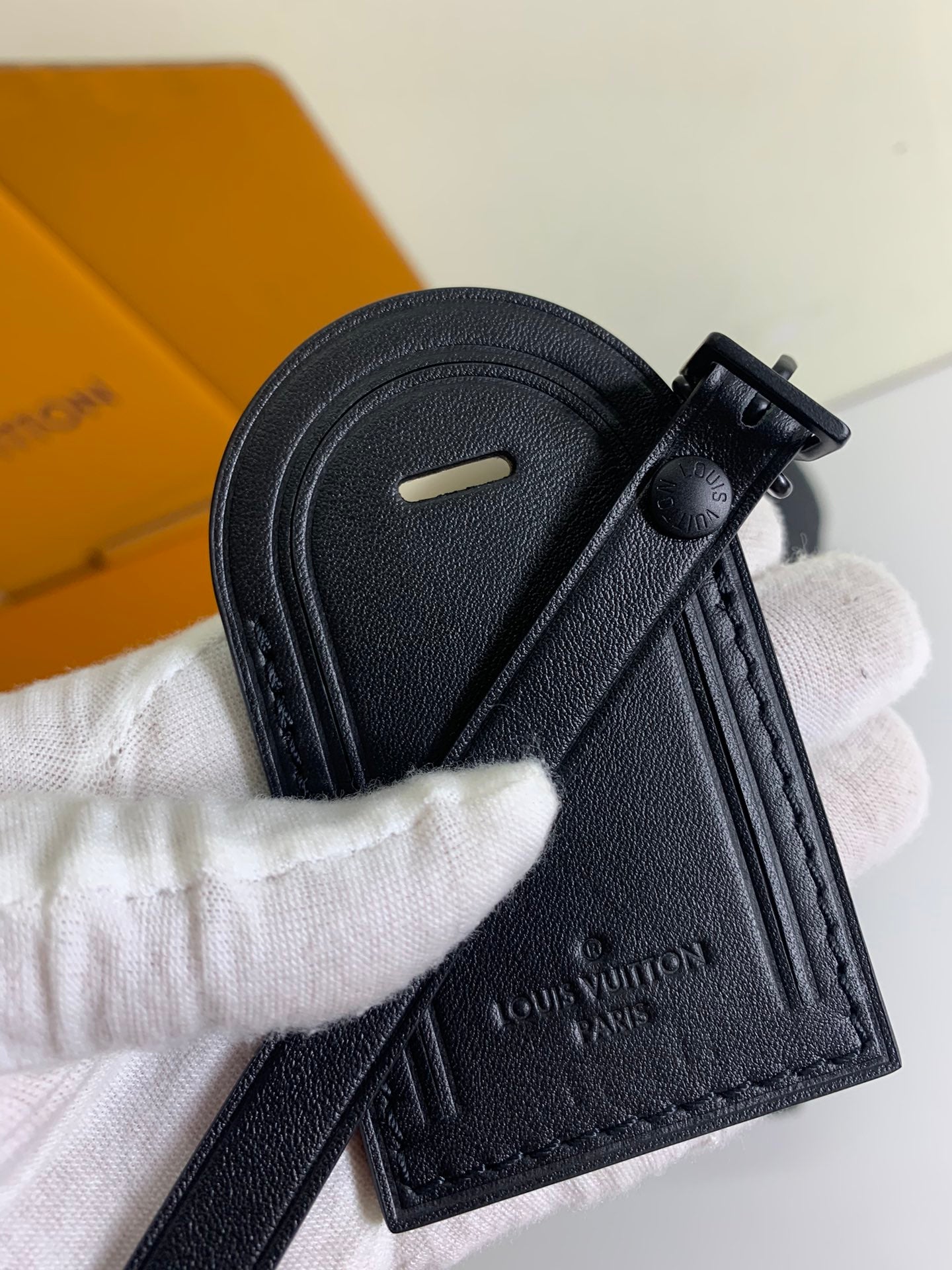Louis Vuitton dark leather key holder with snap and monogram-embossed tag
