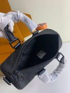 Louis Vuitton dark monogram bag with front zipper and pebble-leather texture