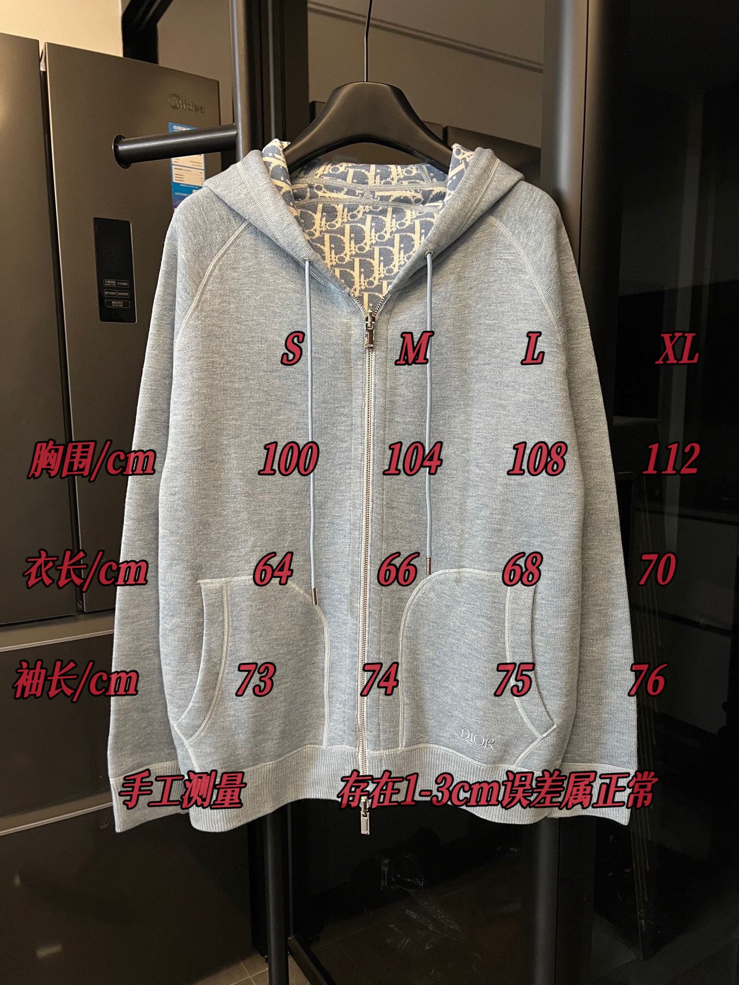 Light gray zip-up hoodie with hood and full front zipper on hanger