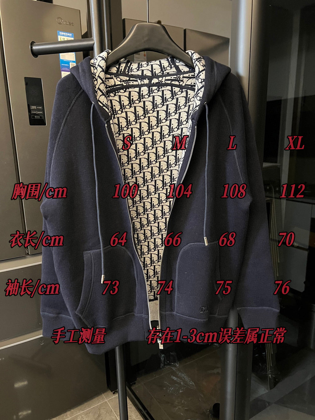 Navy zip-up hoodie with hood and beige Dior monogram lining on a mannequin.