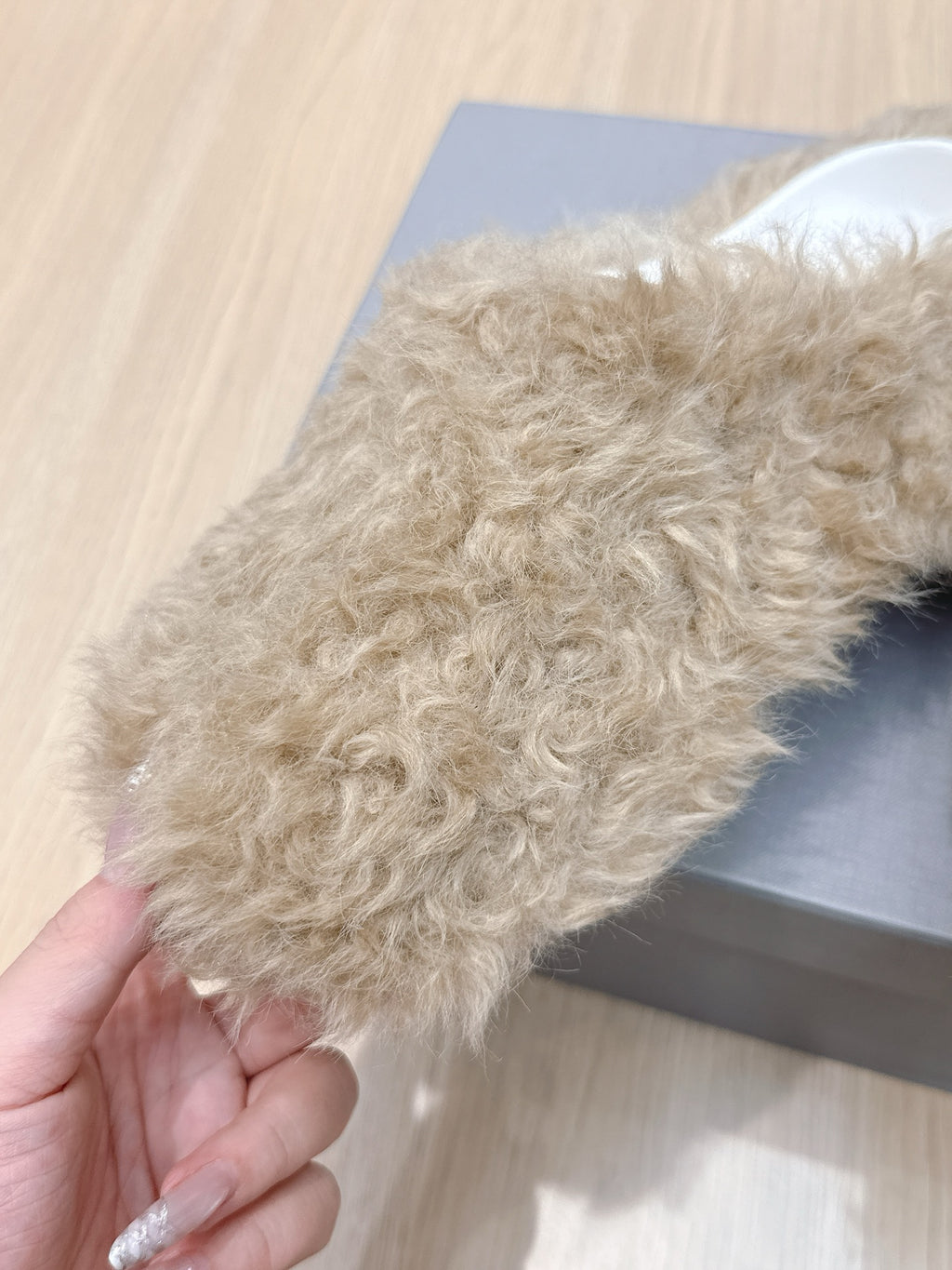 Beige faux-fur slide sandal upper close-up, textured fur detail