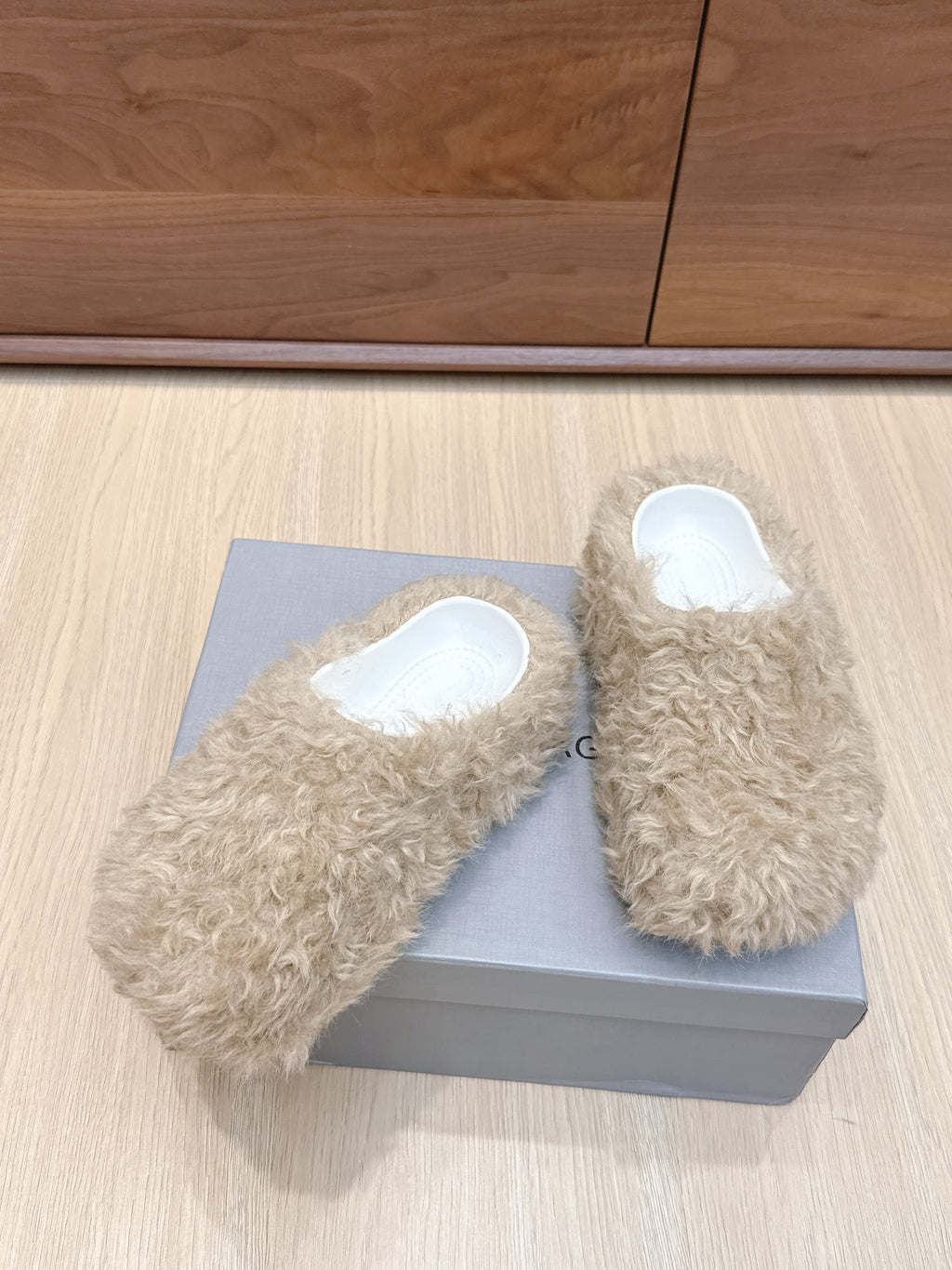 Beige faux-fur slide sandals with white insoles, close angle