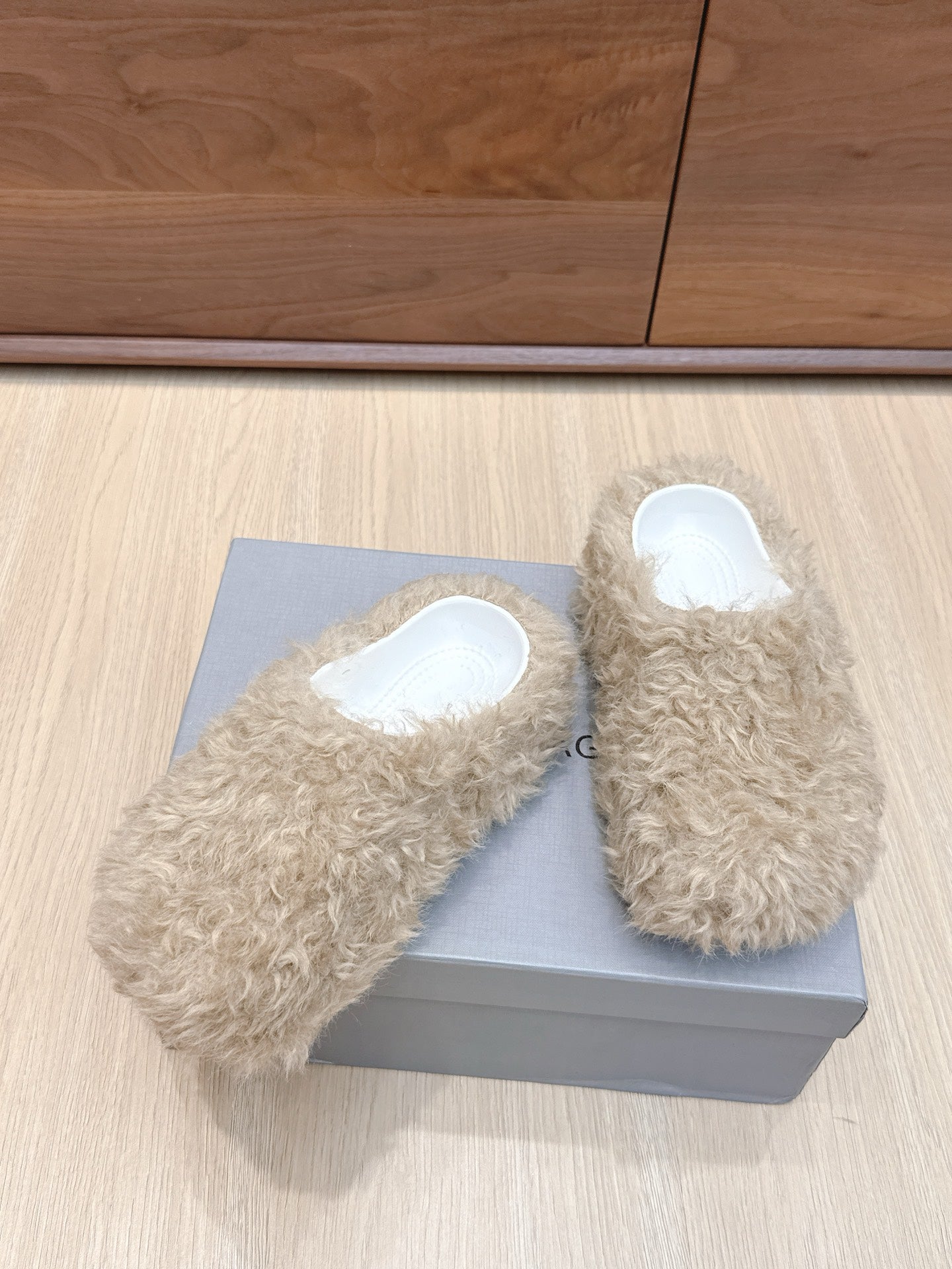 Beige faux-fur slide sandals with white insoles, close angle