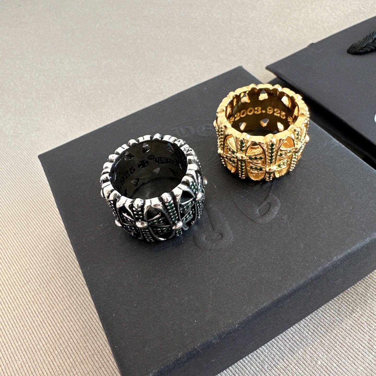 Chrome accessories two rings on black display card, gold and black with green accents