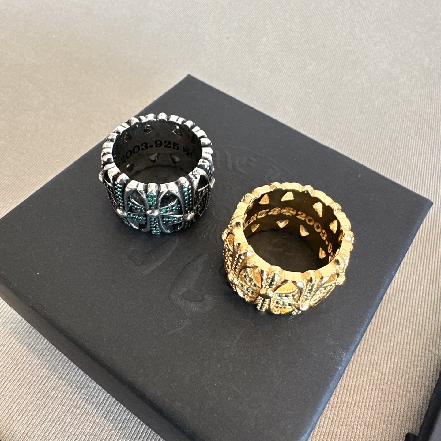 Chrome accessories pair of rings on black card, silver tone with green stones and gold ring