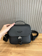 Black small flap crossbody bag with front buckle strap and logo emblem