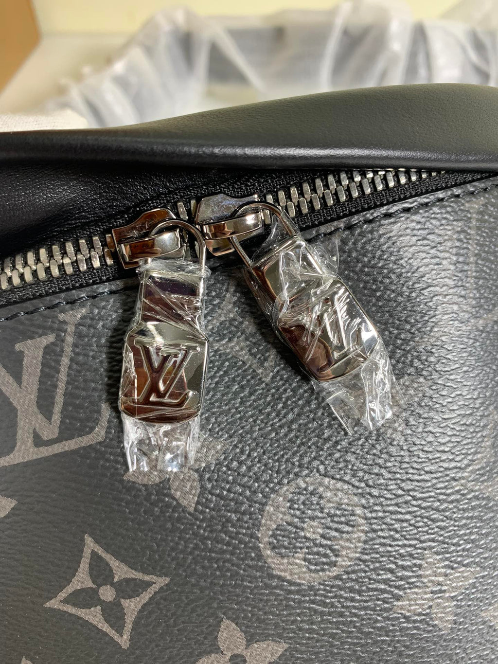 Black monogram belt bag close-up of zipper pull and metal hardware