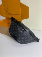 Black monogram belt bag lying on box, with adjustable strap and hardware