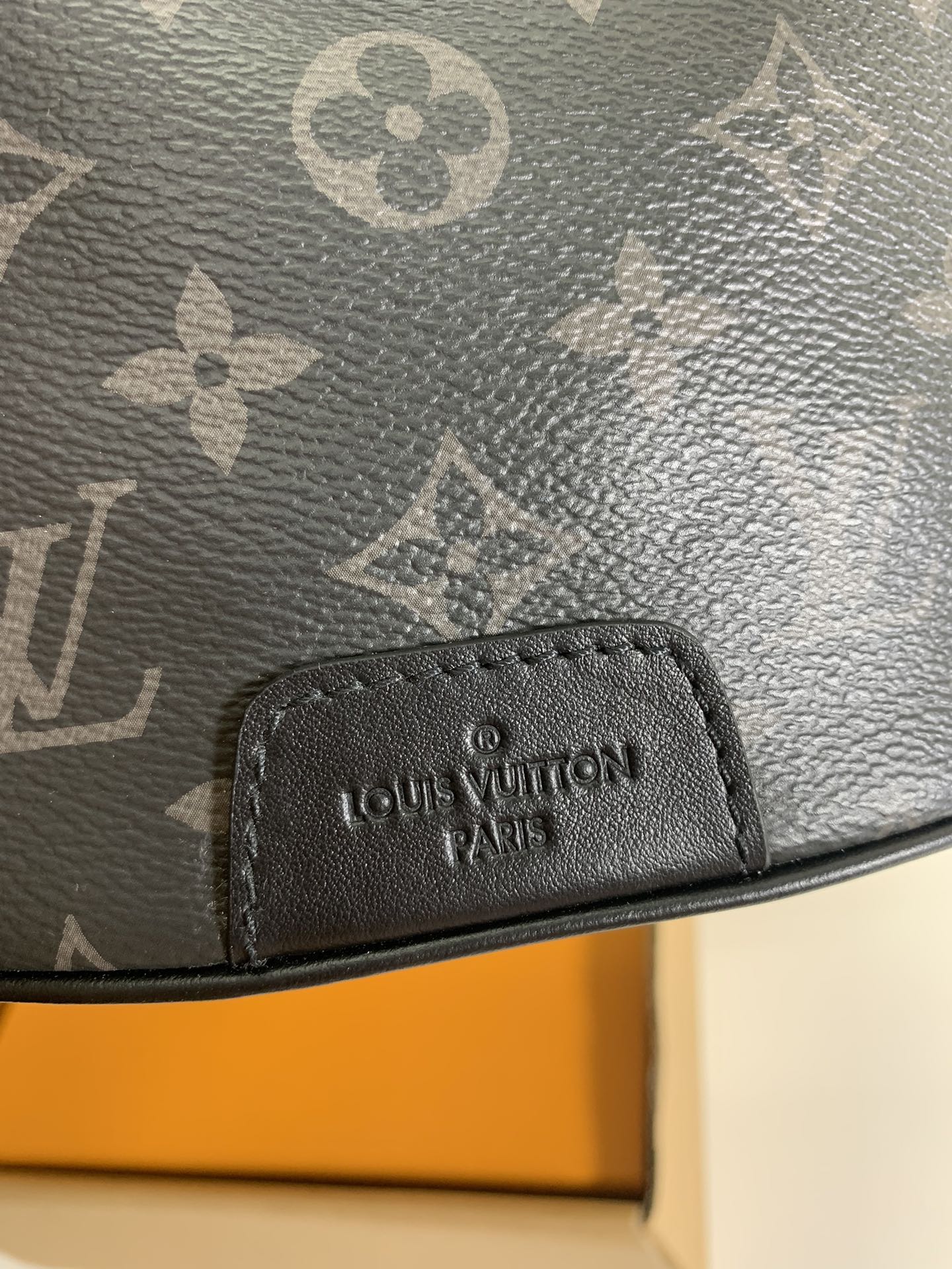 Black monogram belt bag with stitched brand logo patch on front