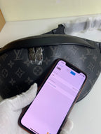 Black monogram belt bag with smartphone placed inside front compartment