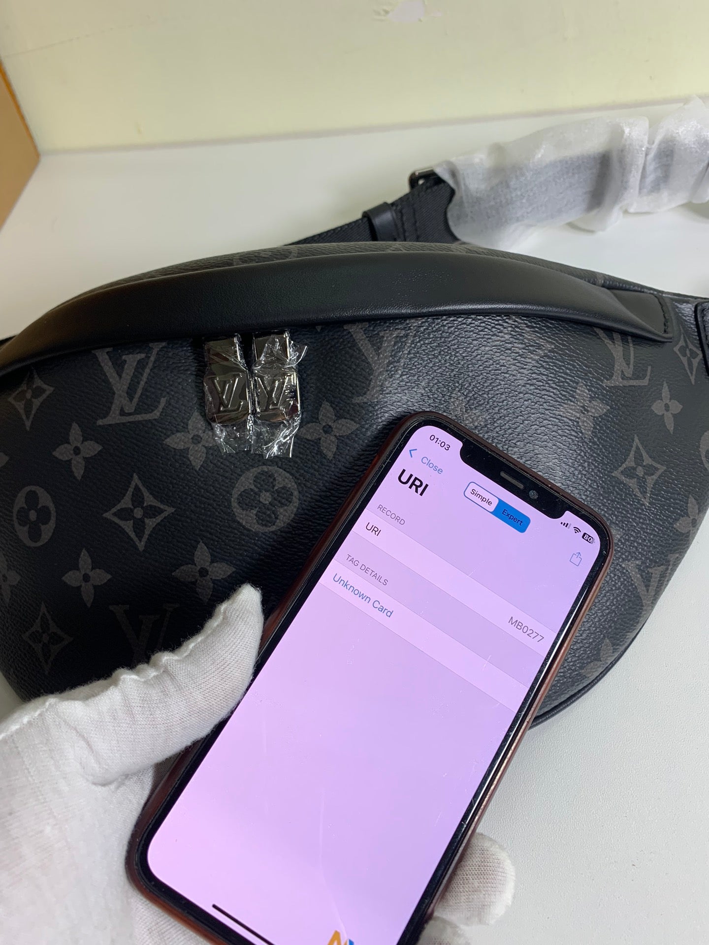 Black monogram belt bag with smartphone placed inside front compartment