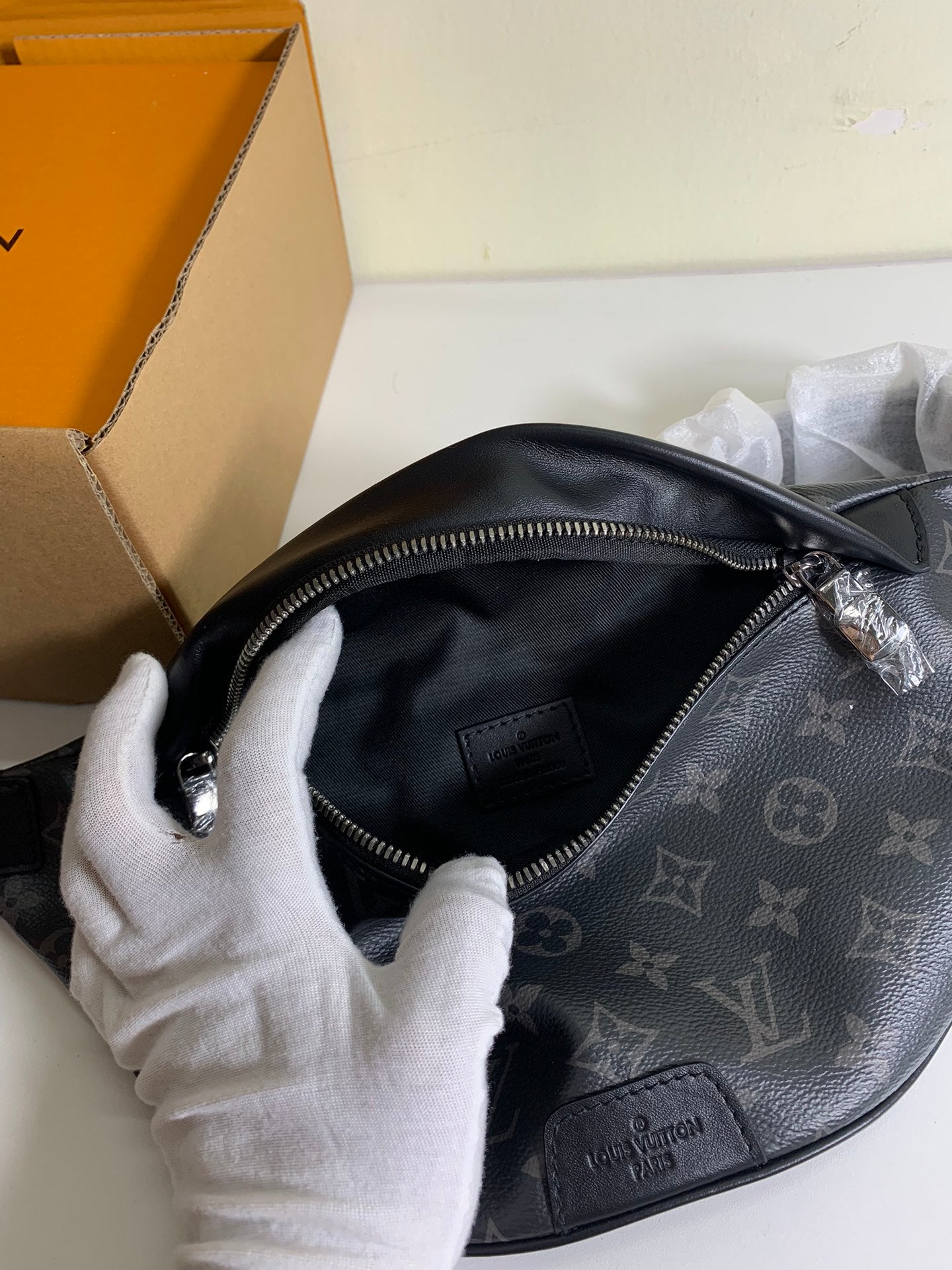 Black monogram belt bag open interior with zipper and leather logo patch