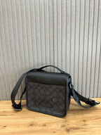 Coah crossbody bag front view; black top flap, dark patterned body, shoulder strap