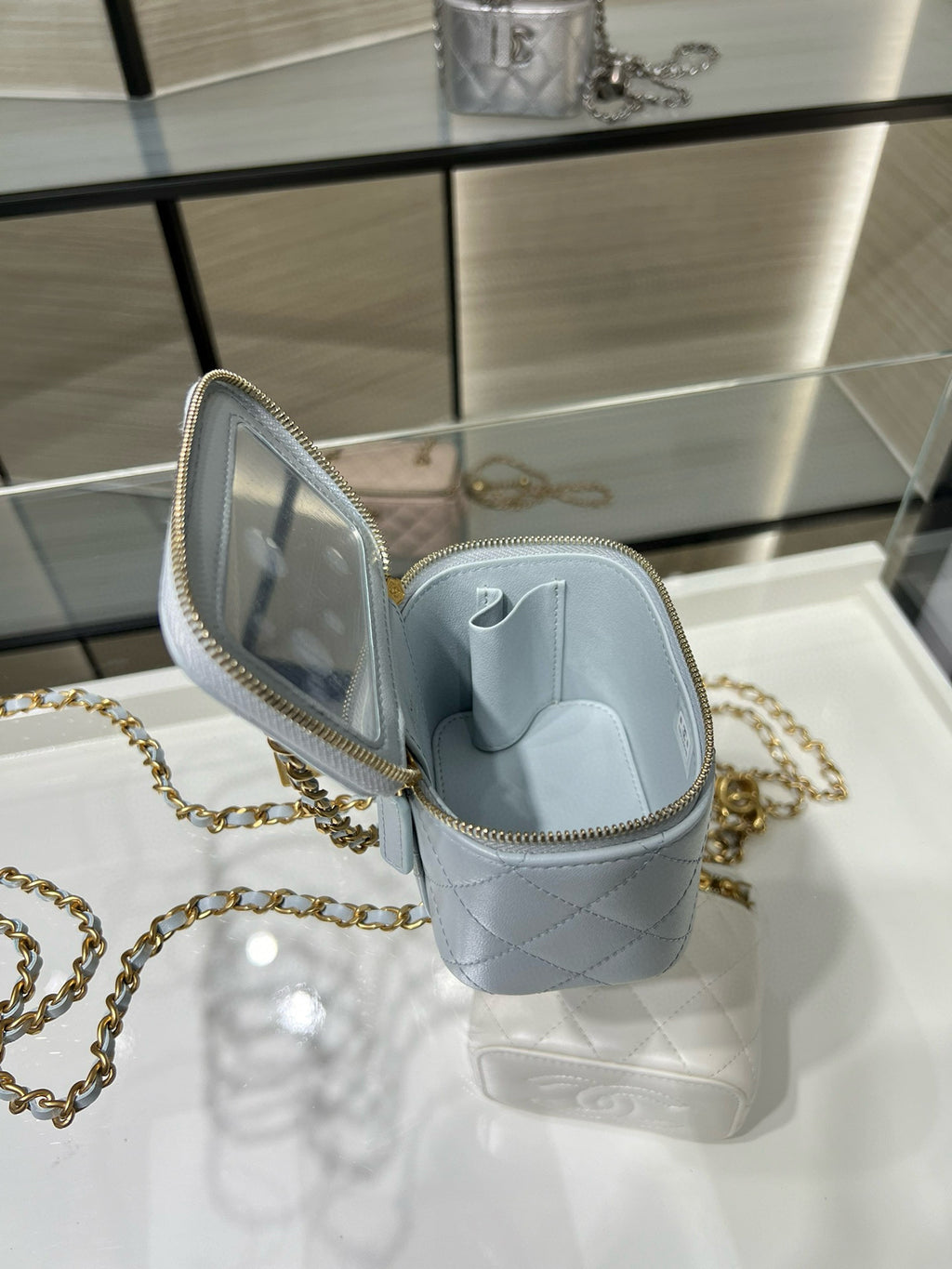 Light blue Chanel mini bag opened showing interior compartment and gold zipper