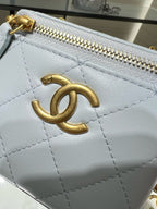 Close-up of Chanel light blue quilted bag with gold CC logo and zipper pull