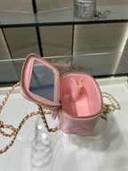 Pink Chanel mini bag open to reveal pink interior with zipper and chain strap.